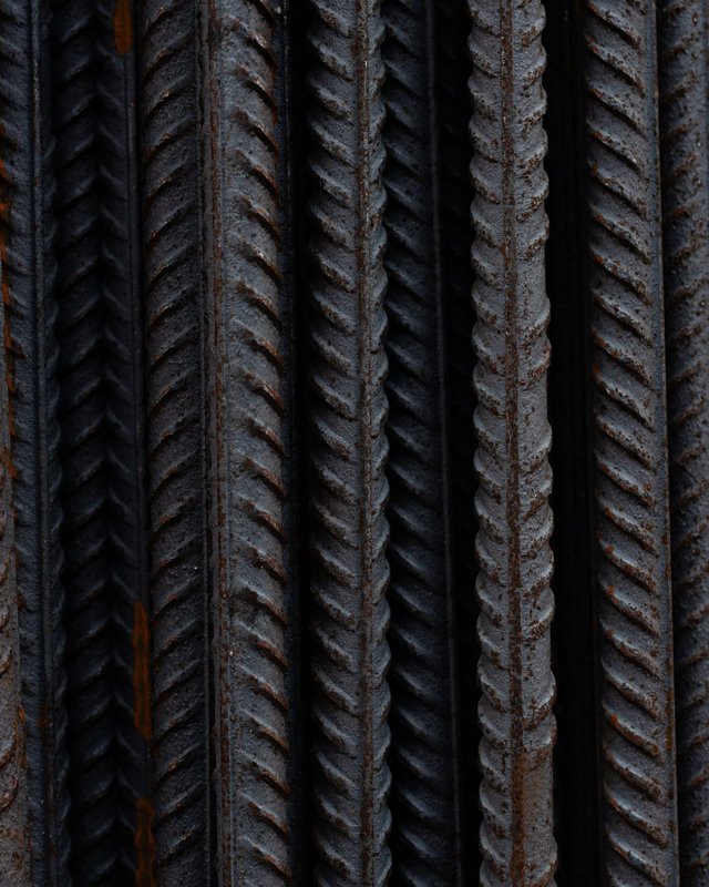 Close-up of deformed reinforcing bar, its ribs showing light rust